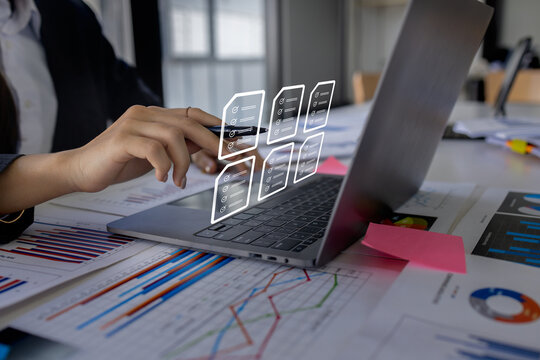 Document management concept with icons on virtual screen, ERP, Businessman working on laptop computer keyboard with electronics document	
