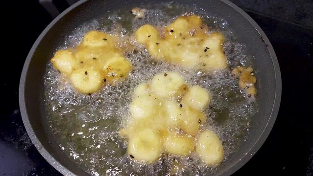 Deep frying cube potatoes in the pan, top view and close up.