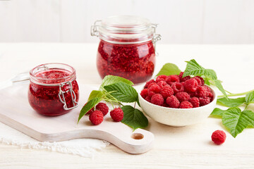 Homemade jam. Jars of raspberry jam and a bowl of fresh berries. 
