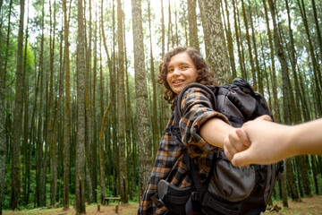 Asian woman trekking in the forest by holding hands