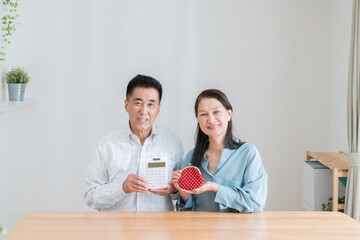 計算機と財布を持つシニア夫婦（老後・お金・貯金）