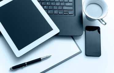Modern workplace with digital tablet, laptop, pen and papers