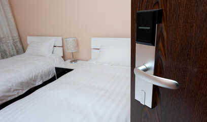 Opened door with blurred background of white bed in hotel room