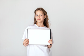 White banner .Teenager girl hold white blank paper. Young smiling woman show blank board. Close up...
