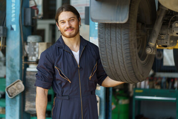 mechanic worker checking car replacing car wheel and tyre in auto repair shop store service. worker...