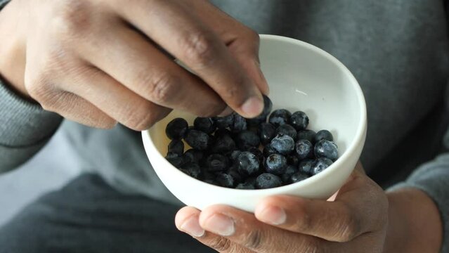 Close up of men hand pick fresh blue berry in a bowl 
