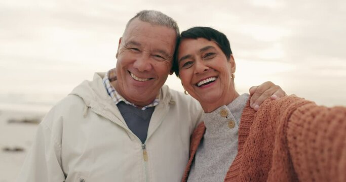 Old couple, hug and selfie on the beach, happiness and retirement together, travel and memory outdoor. Portrait, happy people in picture and pension with holiday, marriage and commitment with sunset