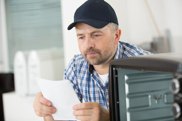 serviceman reading installation instructions for appliance