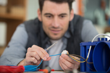 young serviceman working on broken electric machine