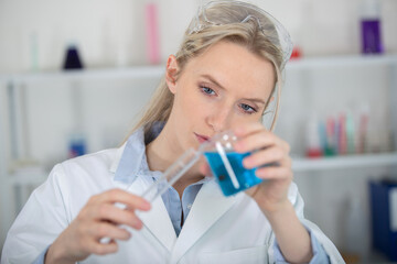 scientist woman in lab uniform making clinical experiment