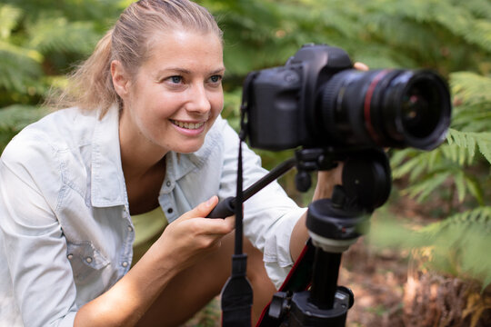 pretty female photographer taking photos in nature