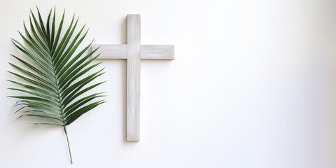 Palm Sunday. Cross and palm leaf on a white wall background with copy space.