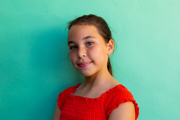Obraz premium Portrait of happy caucasian schoolgirl wearing dress over blue background