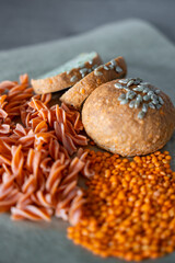 Red lentil fusilli pasta and Vegan Lentil Bread on a gray background. Gluten free food