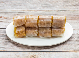 rice noodle rolls filled with twisted cruller served in dish isolated on wooden table top view hong kong food