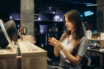 Shopping a new digital device. Happy beautiful woman choosing a smart watch in tech store