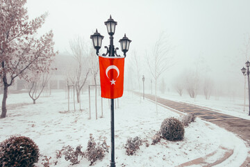 Rustic street lamp and Turkish flag on it in snowy weather