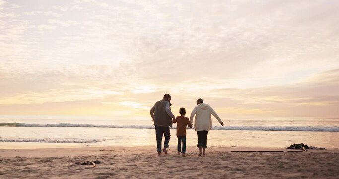 Holding hands, sunset and grandparents with a child at the beach for playing, bonding or a vacation. Back, family and senior man, woman and a kid at the ocean for a holiday at night in summer