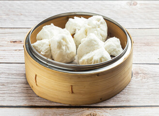 steam honey glazed bbq pork buns with saucy filing served in dish isolated on wooden table top view hong kong food