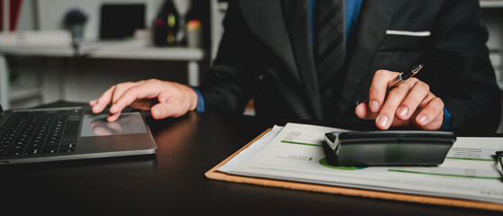 Portrait of man working on tablet computer in modern office make account analysis report Real...