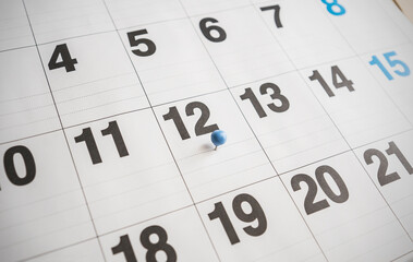 Twelfth day of the month marked with a pin on the calendar