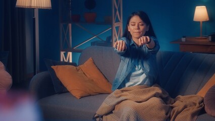 Female sleepwalker sits on a sofa in the living room close up. Somnambulism.