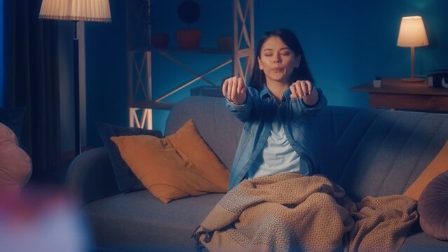 Female sleepwalker sits on a sofa in the living room. Somnambulism.