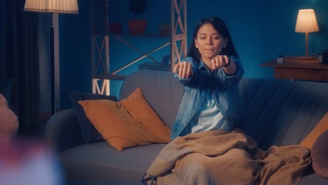 Female sleepwalker sits on a sofa in the living room close up. Somnambulism.