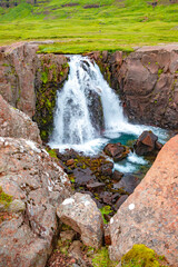 Obraz premium Small waterfall and river in fjords at the hiking trail near Seydisfjordur in Iceland, summer