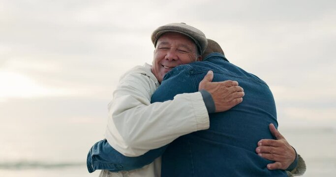 Elderly father, man and hug at beach with love, care and bonding on vacation, holiday or travel outdoor at sunset. Senior dad, adult son and embrace at ocean, sea and happy family talking together