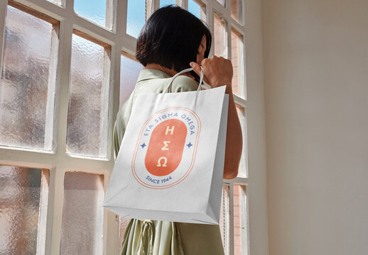 Mockup of woman holding customizable paper shopping bag over shoulder, close up