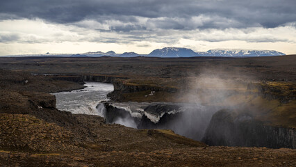 Areal view over dettifoss waterfall in iceland in summer in moody weather with dramatic clouds in the sky