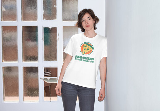 Mockup of woman wearing t-shirt with customizable color by window, camera flash