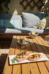 close-up bruschetta, sandwich, cake, fruit for breakfast on a wooden table in a cozy interior of a terrace
