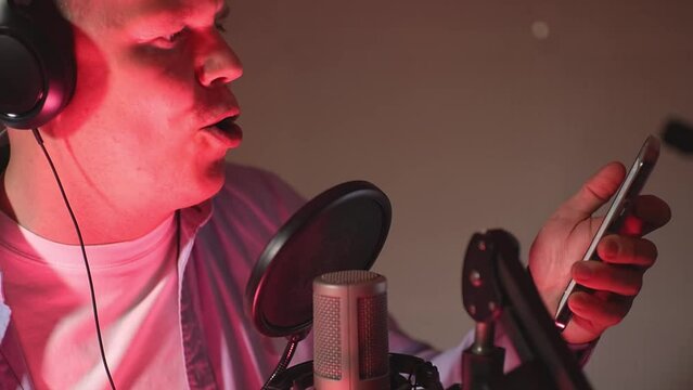 aggressive man reads text from smartphone. aggressive man sings songs. a man reads a text from a smartphone. High quality Full HD video recording