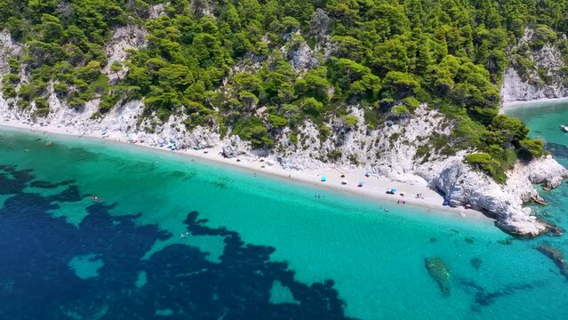 Panoramic aerial view of the beautiful Hovolo beach, Sporades, Greece, with turquoise sea and lush pine tree forest