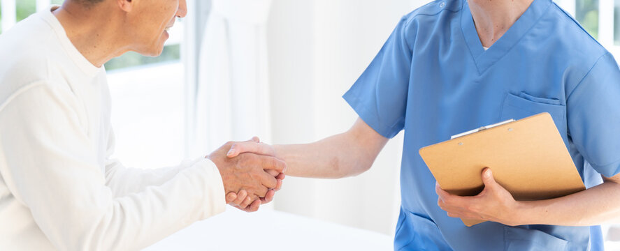 握手する医者とシニア患者