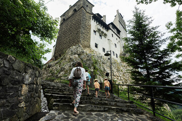 Family of tourists with children visit the old castle Bran, Romania.