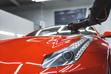 taking care of an orange car at the repair shop, polishing and cleaning a car. High quality photo