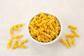 Raw Macaroni pasta served on white bowl
