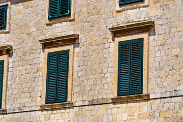 Fototapeta na wymiar street view of the old town of Dubrovnik in Croatia, medieval European architecture, city streets, windows with wooden shutters, red tiled roofs, the concept of traveling in the Balkans