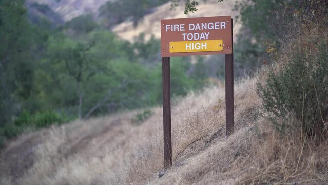 Wildfire Danger Warning Sign next to road in California, Medium Shot