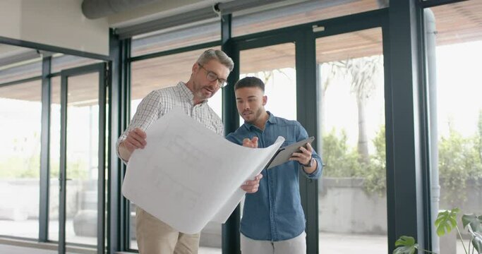 Two diverse mele architects with digital tablet and a plan discussing at office