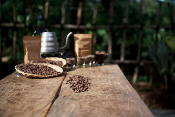Fototapeta premium Rosted Arabica Coffee Bean on the Table with Natural organic farm Background
