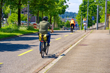 Urban road with bicycle lane and cyclists at City of Zürich on a sunny spring day. Photo taken May...