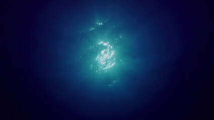 View of sun light from blue abyss, slow motion. Light filters down through blue water. Underwater...