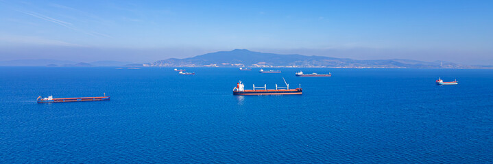 Bulk dry cargo ships anchored in sea waiting loading in industrial port. wide photo