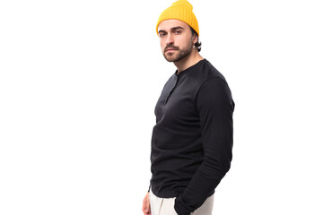 courageous handsome young 30 year old guy with a beard dressed in a black jacket and a yellow hat