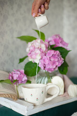 Pink hydrangea, a cup of coffee and a book. Relax on the couch