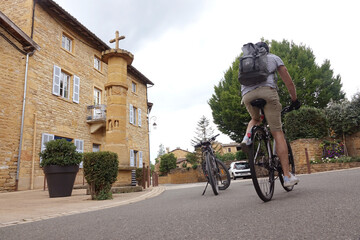 Cycliste en faisant du vélo dans le village de pierres dorées de Theizé, dans le Beaujolais,...